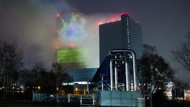 Aktivist*innen projizieren verschiedene Bilder auf den Kühlturm des Kohlekraftwerks Datteln 4