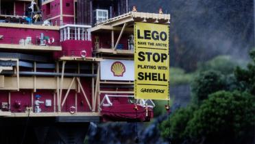 Protestbanner am einem Modell einer Ölplattform von Shell im Legoland in Dänemark.