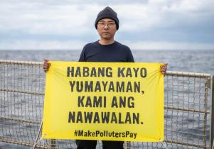 Aktivist Yeb Saño an Bord der Arctic Sunrise mit Banner gegen Shell. Er schaffte es leider nicht auf die Plattform.