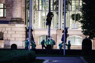 Im Dunkeln klettern Greenpeace-Aktive die Fahnenstangen empor