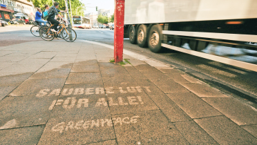 Kreideschriftzug "Saubere Luft für alle" auf dem Gehsteig an der Max-Brauer-Allee in Hamburg. Auf einem Teil der Straße gilt das Fahrverbot für Diesel bis Euro-Norm 5.