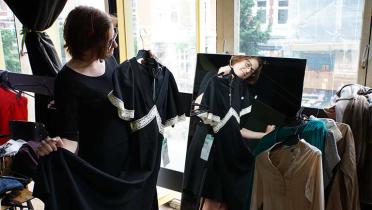 Eine Besucherin der Kleidertauschparty in Hamburg zeigt ihr Kleid.
