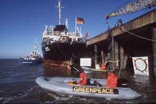 Greenpeace-Aktivisten im Schlauchboot protestieren gegen das Dünnsäure-Verklappungsschiff "Kronos" im Hafen von Nordenham, Mai 1980