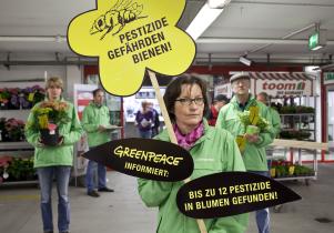 Greenpeace Aktivisten versehen Pflanzen aus Baumärkten mit Etiketten: Achtung bienengefährdende Pestizide! Mai 2014