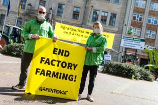Ein Mann und eine Frau halten einen Banner mit dem Spruch: End Factory Farming in die Kamera