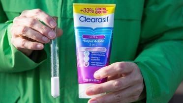 Reagenzglas mit Mikroplastik und Kosmetiktube