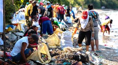 Mehre Dutzend Menschen sammeln Müll am Strand von Freedom Island bei Manila