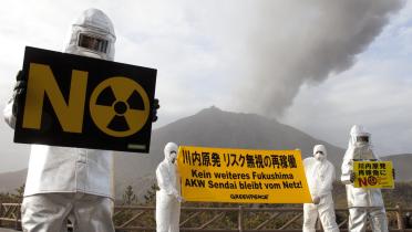 Greenpeace Aktivisten protestieren vor einem Vulkan gegen die Reaktivierung des Kraftwerks Sendai