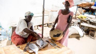 Zwei Frauen an einem Marktstand mit Fisch