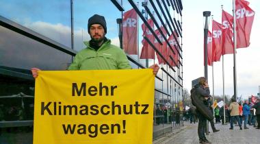 Greenpeace-Aktivist mit "Mehr Klimaschutz wagen"-Banner vor SPD-Parteitag in Bonn