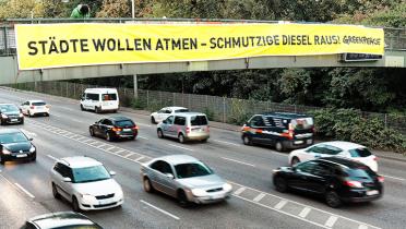Stuttgarter Neckartor mit Banner über Brücke: "Städte wollen atmen, schmutzige Diesel raus!"