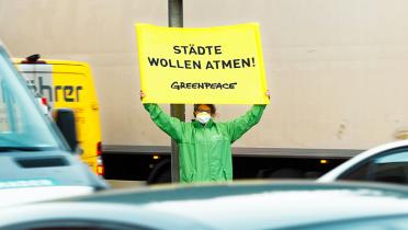 Greenpeace-Aktivist mit Banner in Stuttgart