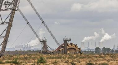 Schqaufelradbagger im Tagebau Hambach, dahinter das Braunkohlekraftwerk Neurath