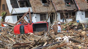Mann auf den Philippinen in den Trümmern seines Hauses, das der Taifun Haiyan zerstört hat.