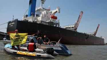 Aktivisten malen „G8, lasst Venedig nicht untergehen“ an die Wand eines Kohleschiffes, Juli 2009