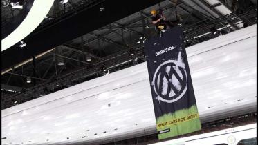 Aktivisten hängen VW Darkside Banner bei Autoshow in Genf