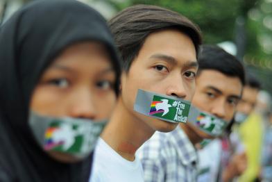 „Global Day of Solidarity“ in Indonesien: Greenpeace-Freiwillige und Unterstützende protestieren mit Bannern für die Arctic 30