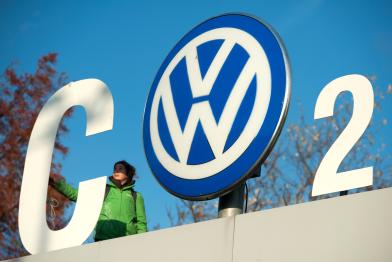 Greenpeace-Aktivist:innen protestieren während einer VW-Vorstandssitzung in Wolfsburg gegen Autoabgase am VW-Werkstor. Die Aktivist:innen verwandeln das VW-Logo in ein CO2-Zeichen. 