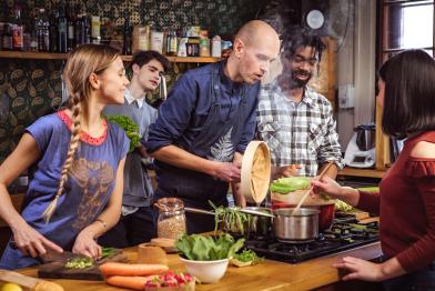 Junge Menschen kochen gemeinsam vegetarisches Essen