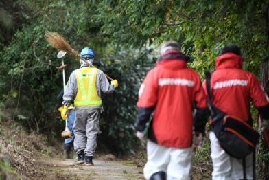 Arbeiter und Greenpeace-Strahlenspezialisten in Namie, Präfektur Fukushima