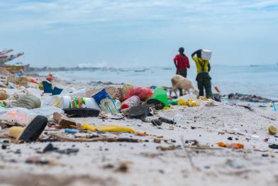Menschen säubern den Strand im Senegal. Die Strände sind mit Plastikmüll und vom Meer angespülter Verschmutzung übersät.