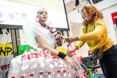 Make Something Day in Hamburg: Aktivistin erstellt aus Plastikflaschen und Dosen ein Kleid an einer Schaufensterpuppe.