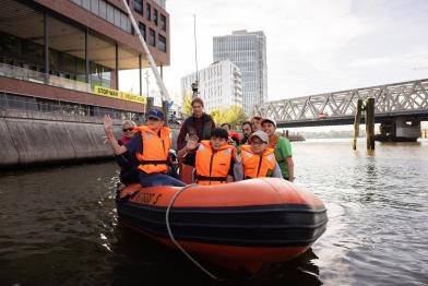 Schüler:innen untersuchen im Schlauchboot auf der Elbe das Wasser