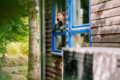 Mira Jäger schaut aus dem Fenster, Wärmepumpe im Vordergrund