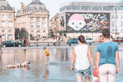 Hitzewelle in Bordeaux, Frankreich, Sommer 2020: Menschen spazieren im Wasser.