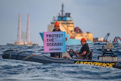Protest gegen Tiefseebergbau im Pazifik Victor Pickering, ein Aktivist von Greenpeace-International aus Fidschi, zeigt ein Banner mit der Aufschrift "Protect the Oceans" (Schützt die Ozeane) vor der Maersk Launcher. Das Schiff wurde von DeepGreen gechartert, einem der Unternehmen, die die Ausbeutung des kaum verstandenen Ökosystems der Tiefsee vorantreiben. Die Rainbow Warrior befindet sich in der Clarion Clipperton Zone im Pazifik, um Zeugnis von der Tiefseebergbauindustrie abzulegen. 