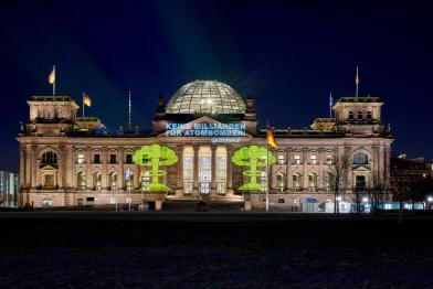 Greenpeace-Aktivist:innen protestieren vor dem Reichstagsgebäude gegen neue Atombomber