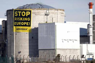 AKW Fessenheim mit Tank für abgebrannte Brennelemente und Greenpeace-Banner am Dach des Reaktors