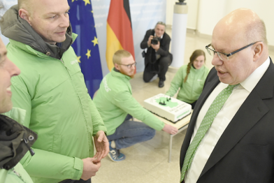 Greenpeace-Aktivisten überreichen Bundeswirtschaftsminister Peter Altmaier eine Torte mit Kohlekraftwerken aus Marzipan.