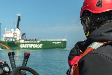 Arctic Sunrise im Sylter Außenriff, Aktivist auf Schlauchboot im Vordergrund