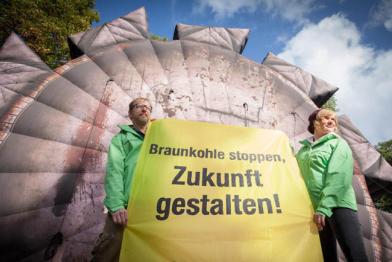 Greenpeace Aktivisten demonstrieren bei den Koalitionsverhandlungen zwischen SPD und Die Linke in Brandenburg für den Kohleausstieg. Vor dem Tagungshotel fordern sie mit einem aufblasbaren Braunkohle-Baggerrad und einem Banner: "Braunkohle stoppen, Zukunf