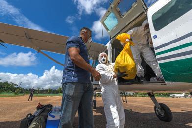 Flugzeug wird von Menschen mit Masken entladen