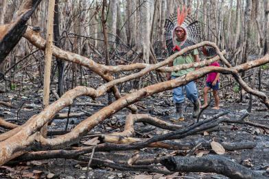 Mitglieder des  Huni Kuin-Stammes laufen durch verbrannten Amazonas-Regenwald