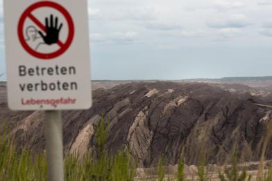 "Betreten verboten" Schild vor einem Braunkohletagebau