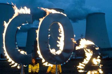 Greenpeace-Aktivisten demonstrieren mit dem brennenden CO2 Zeichen vor dem Braunkohlekraftwerk Jänschwalde, November 2008