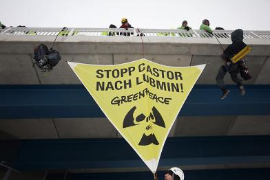 Greenpeace-Kletterer befestigen ein Banner über den Bahngleisen zwischen Greifswald und Lubmin 12/16/2010