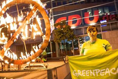 Greenpeace-Aktivisten protestieren mit einem drei Meter hohen glühenden CETA-Symbol vor der CDU-Parteizentrale in Berlin gegen CETA. "Frau Merkel, CETA schadet Umwelt und Demokratie!" sowie "CETA - Brandgefährlich!" stehen auf zwei Bannnern