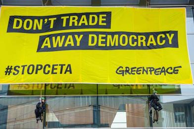 Greenpeace-Aktivisten hängen ein 12 mal 6 Meter großes Banner mit der Aufschrift “Don’t trade away our democracy" an das EU-Ratsgebäude in Luxembourg