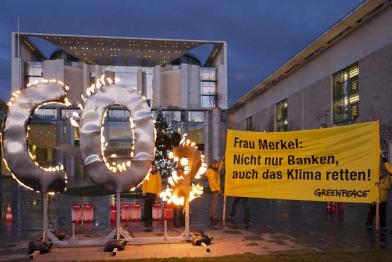 Aktivisten demonstrieren mit brennendem CO2 Zeichen für mehr Klimaschutz vor dem Bundeskanzleramt, Dezember 2011