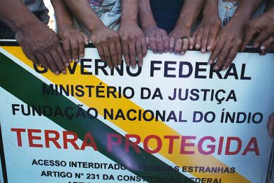 Deni halten ein Schild, das ihre legalen Rechte an ihrem traditionellen Land bescheinigt. 2003/05/10