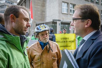 Greenpeace-Kampaigner Daniel Moser im Gespräch mit Verkehrsminister Dobrindt