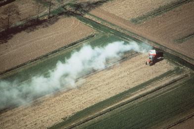 Traktor beim Düngen von Feldern
