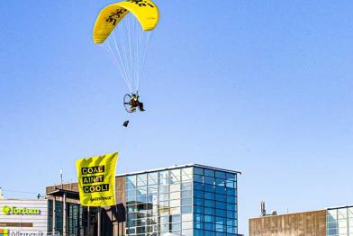 Gleitschirm mit Banner "Coal ain't cool" über dem Fortum-Hauptsitz in Espoo, Finnland