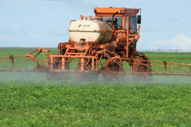 Traktor besprüht Soja-Feld in Brasilien mit Pestiziden