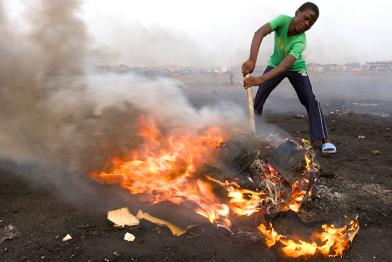 Ein Junge in Ghana beim Verbrennen von elektronischen Teilen