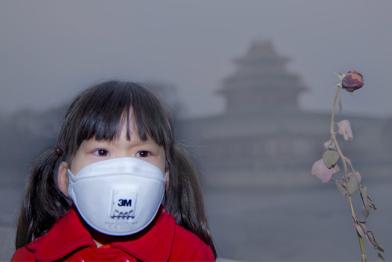 Kind mit Atemschutzmaske in Peking, China